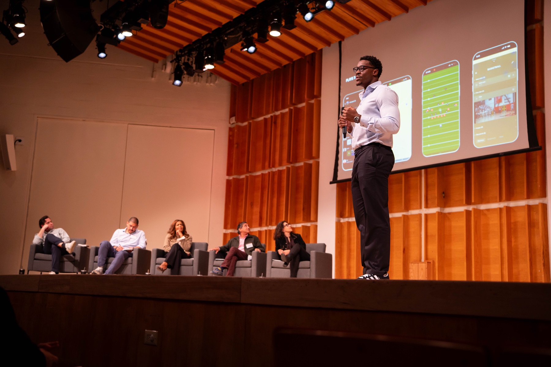 Founder pitching live on stage to alumni Sharks